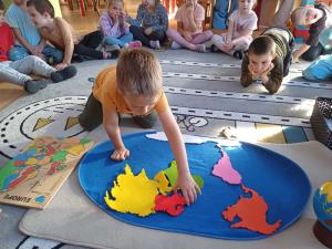 Wlochy-dzieci-z-Montessori-ukladaja-mape-kontynentow